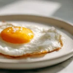 Huevo frito cocinado en una freidora de aire, perfecto para una comida saludable.