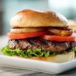 Deliciosa hamburguesa cocinada en freidora de aire, crujiente y jugosa.